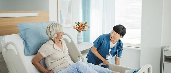 Krankenhauszuzahlungen – Patientin im Krankenhaus mit Krankenpflegerin